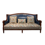 Un canapé en bois sombre avec un motif de fleurs dans des tons pastel et un rembourrage en cuir bleu marine.