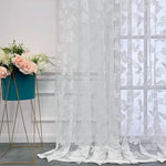 Voilage papillon blanc devant une fenêtre avec une table en bois et une horloge rétro posée dessus.