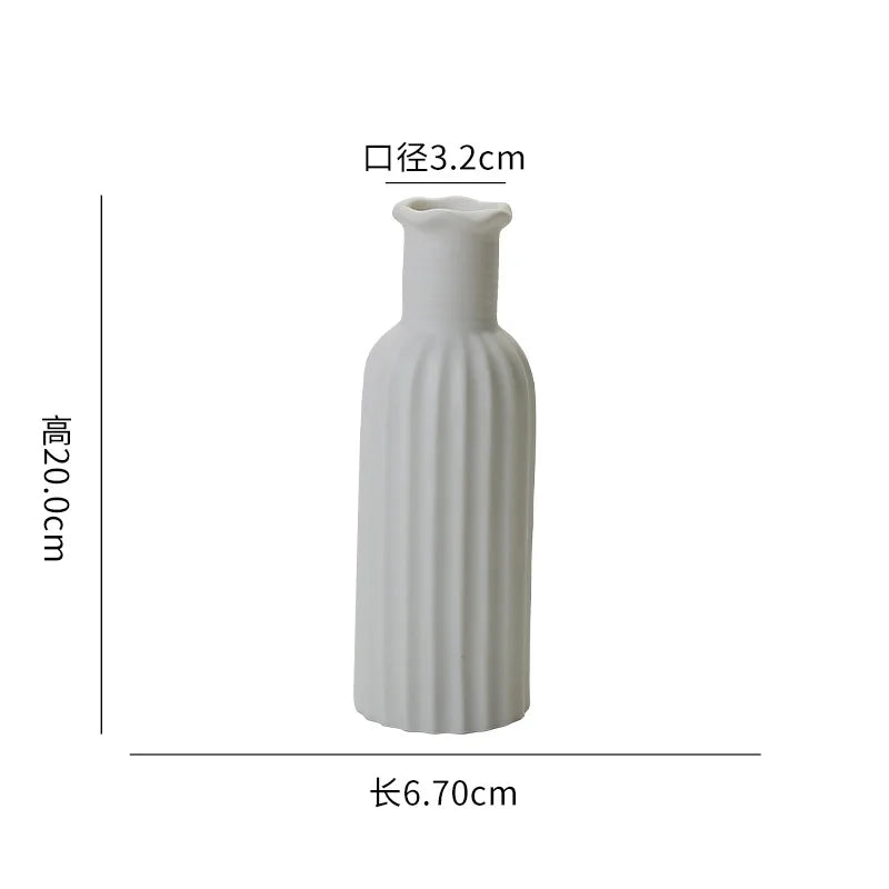 Vase en céramique blanche de design épuré, mesurant 6,70 cm de hauteur et 3,2 cm de diamètre.