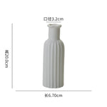 Vase en céramique blanche de design épuré, mesurant 6,70 cm de hauteur et 3,2 cm de diamètre.