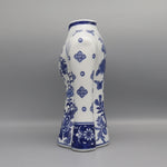 Vase en porcelaine blanche avec des motifs floraux bleus délicats et élégants, créant un contraste saisissant avec son fond clair.