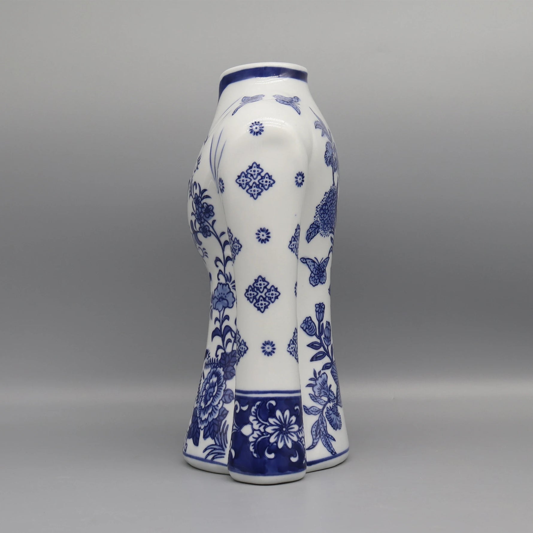 Vase en porcelaine blanche avec des motifs floraux bleus délicats et élégants, créant un contraste saisissant avec son fond clair.