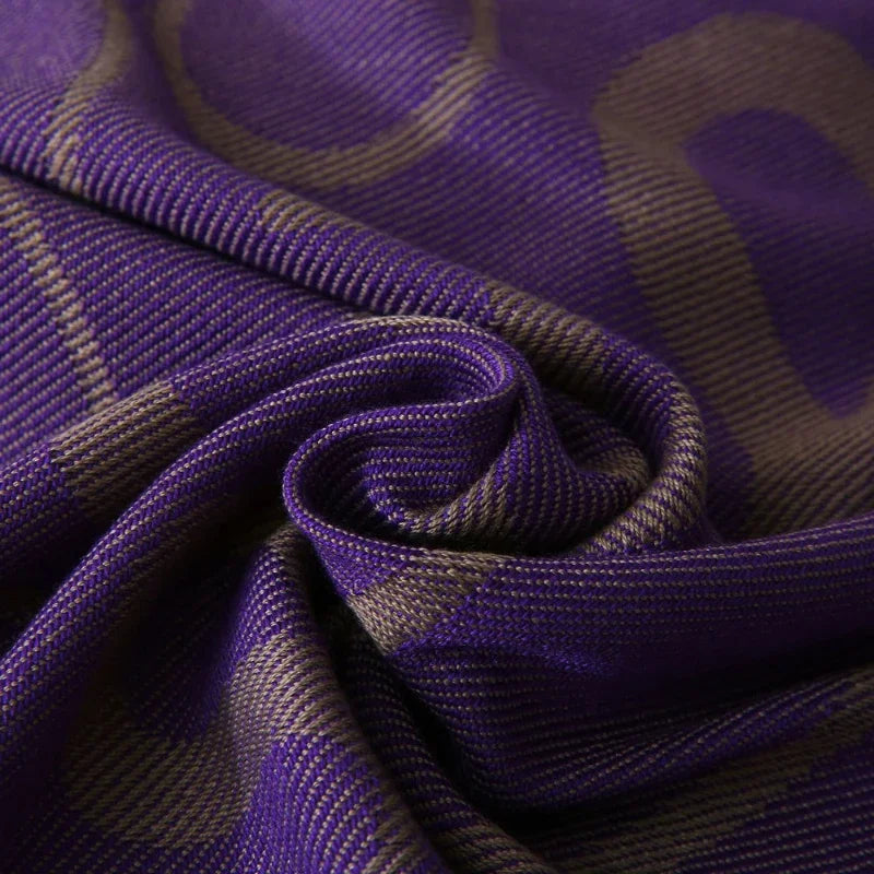 Tissu en soie violette texturé avec des motifs ondulés créant un effet captivant et élégant.