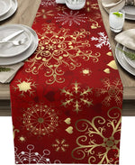 Nappe de table en rouge et or ornée de flocons de neige et de motifs floraux élégants, créant une ambiance festive pour un repas convivial.