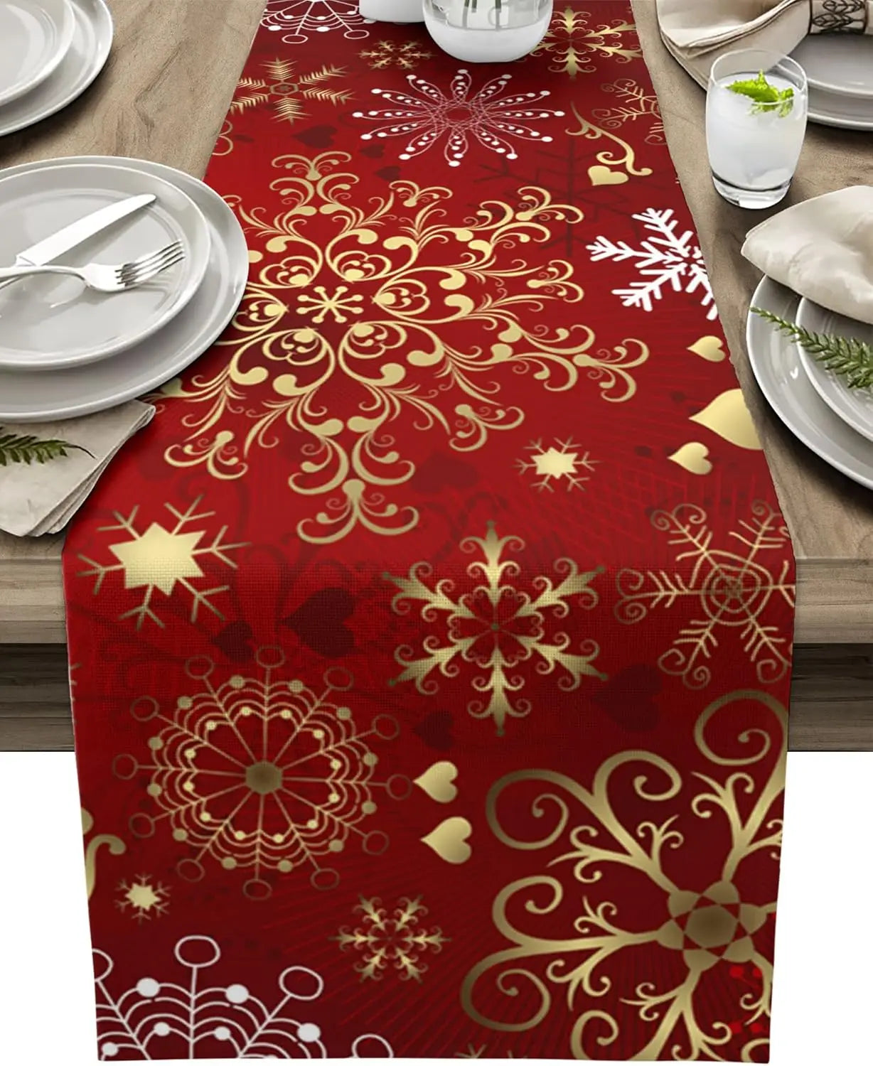 Nappe de table en rouge et or ornée de flocons de neige et de motifs floraux élégants, créant une ambiance festive pour un repas convivial.