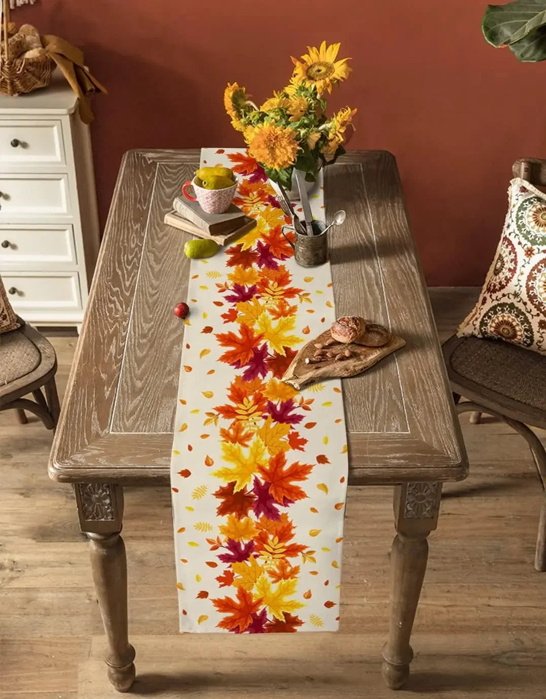 Un élégant arrangement automnal de fleurs d'or et de feuilles oranges sur une table en bois rustique, accompagné de décorations d'automne.