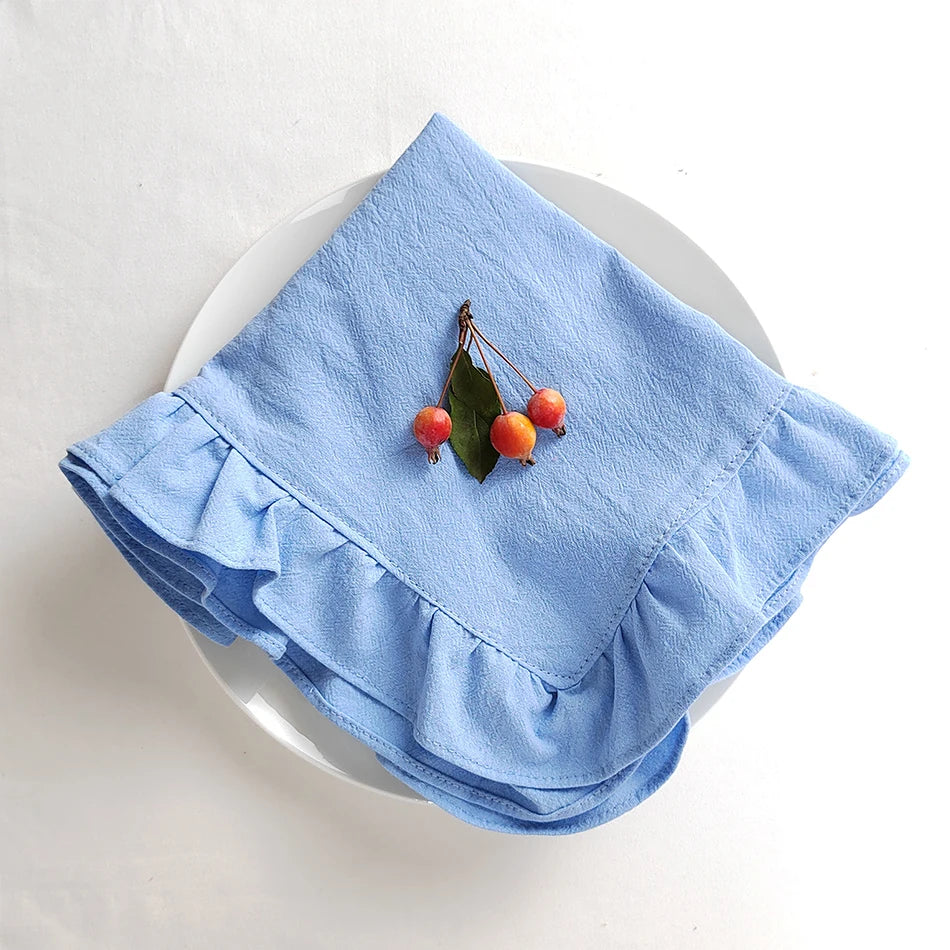 Ce mouchoir bleu clair plissé est décoré d'un bouquet de baies rouges orangées.