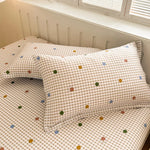 Parure de lit matelassée dans un motif à carreaux de couleurs pastels avec des petits points colorés.