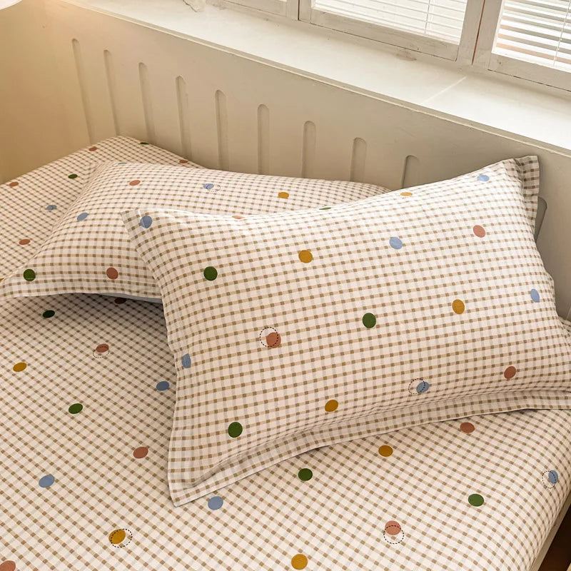 Parure de lit matelassée dans un motif à carreaux de couleurs pastels avec des petits points colorés.