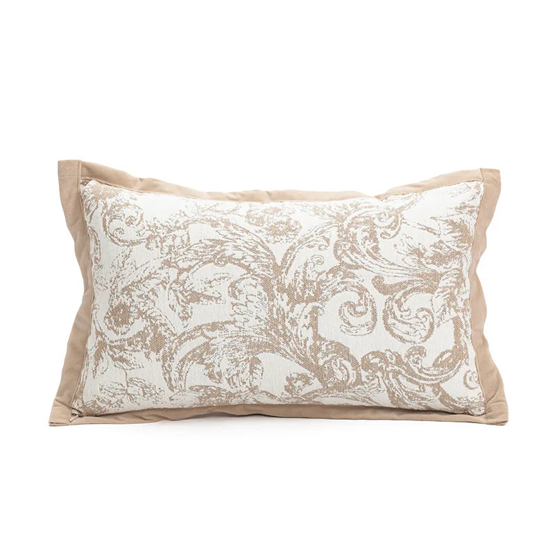 Coussin décoratif avec motif floral en nuances de beige et de blanc sur une surface unie.