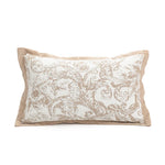 Coussin décoratif avec motif floral en nuances de beige et de blanc sur une surface unie.