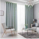 Rideau vert sauge clair avec voilage blanc translucide, installé dans un salon contemporain à la décoration nordique.