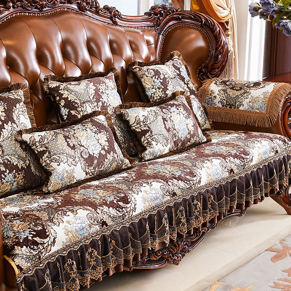 Ce canapé en cuir marron foncé est agrémenté de coussins décoratifs aux motifs floraux riches et élégants, offrant un style sophistiqué et chaleureux à cet espace de salon.