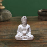 statue bouddha zen blanc gris bois décoratif assiette cigarettes tapis fibres naturellements éléments divers