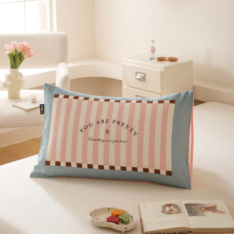 Sur ce coussin, on peut voir une élégante décoration avec des motifs roses et bleus. Le coussin porte l'inscription "You are pretty" qui transmet un message positif et bienveillant.