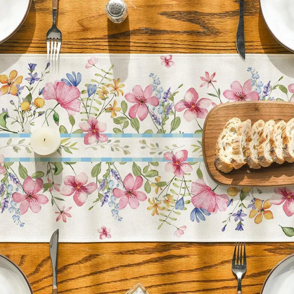 Une table en bois rustique avec une décoration florale colorée et un plat de pain tranché posé dessus, créant une ambiance chaleureuse et conviviale.
