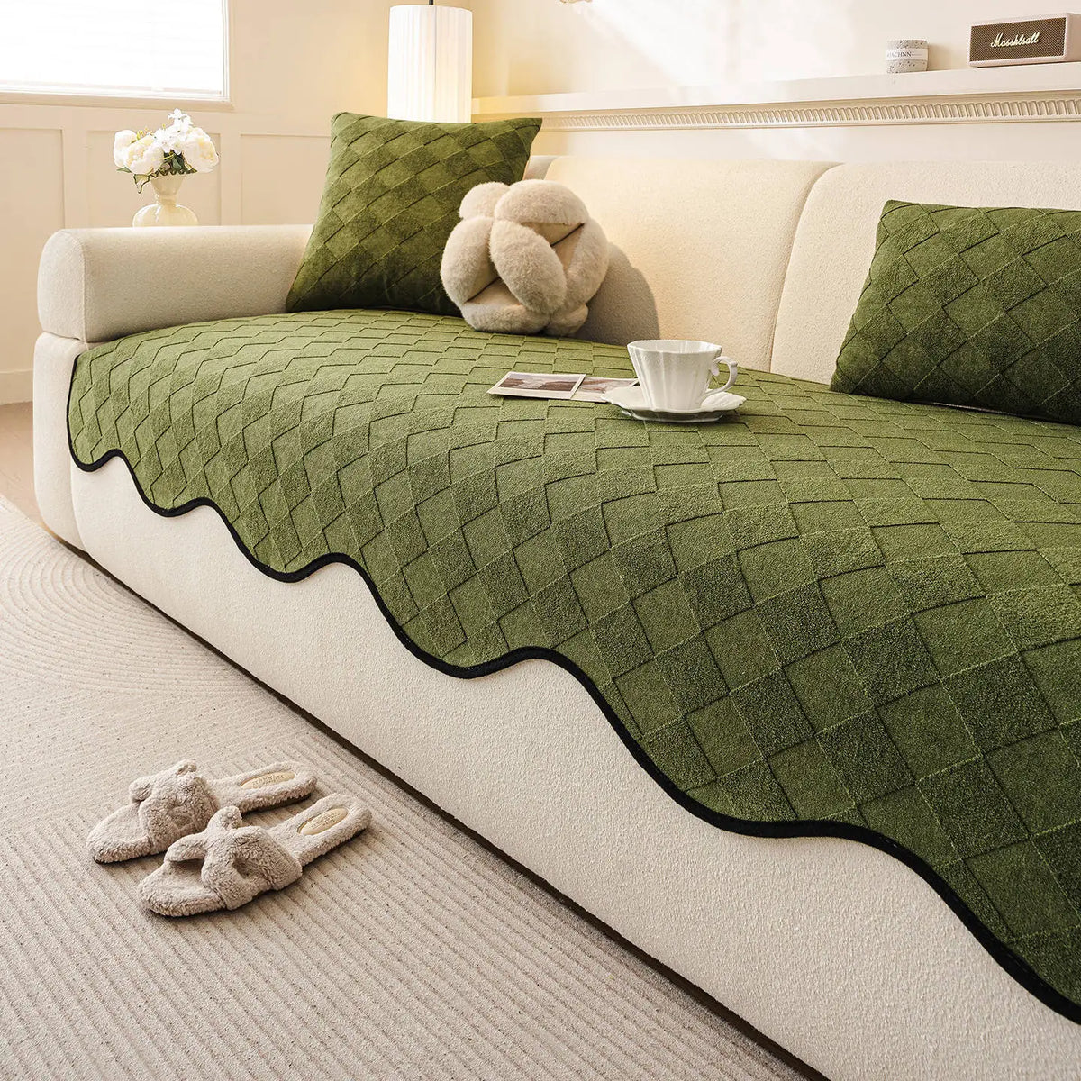 Un canapé confortable dans un intérieur cosy, avec un joli plaid et des coussins décoratifs en vert.