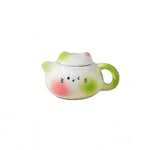 théière forme chat blanc rose vert jaune yeux noirs oreilles roses poils blancs décoration