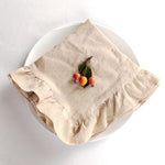 Sur un plat blanc, un linge de table beige porte quelques baies rouges et vertes.