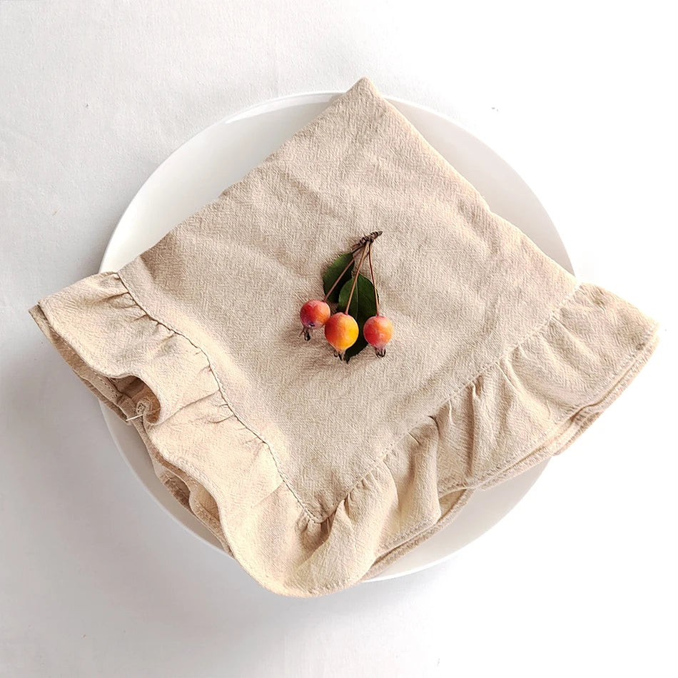 Sur un plat blanc, un linge de table beige porte quelques baies rouges et vertes.