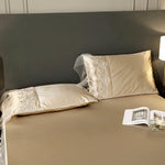 drap lit beige clair broderie fine satiné élégant oreillers taies assorties