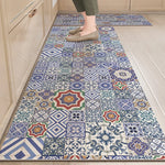 Ce tapis carrelé multicolore présente une variété de motifs géométriques et floraux dans des tons de bleu, de rouge et de jaune sur un sol en carrelage blanc.