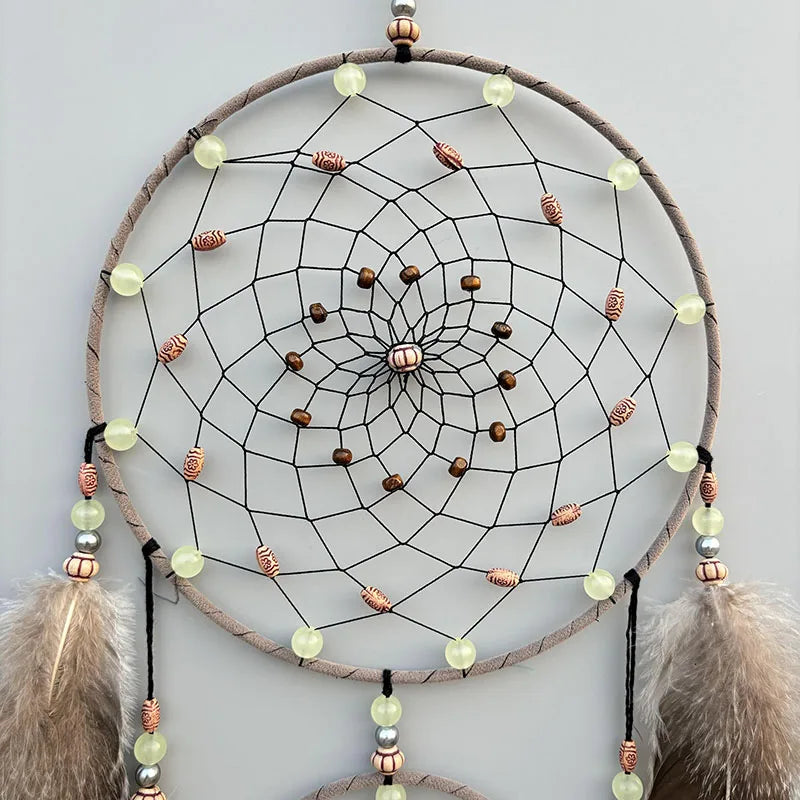 Un magnifique capteur de rêves en cercles concentriques avec des perles et des plumes créant une œuvre d'art ethnique.