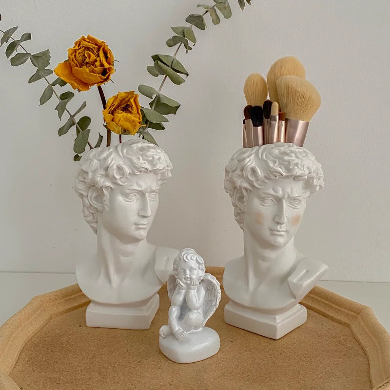 Cache-pot tête humaine rouge avec petite plante succulente en décoration intérieure
