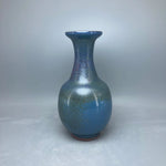 Un élégant vase en céramique aux teintes bleutées et nacrées, reflétant une finition artistique raffinée.