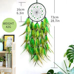 Un capteur de rêves décoratif en plumes vertes et jaunes, d'un diamètre de 16 cm et d'une longueur totale de 73 cm, suspendu sur un fond blanc avec des éléments de décoration.