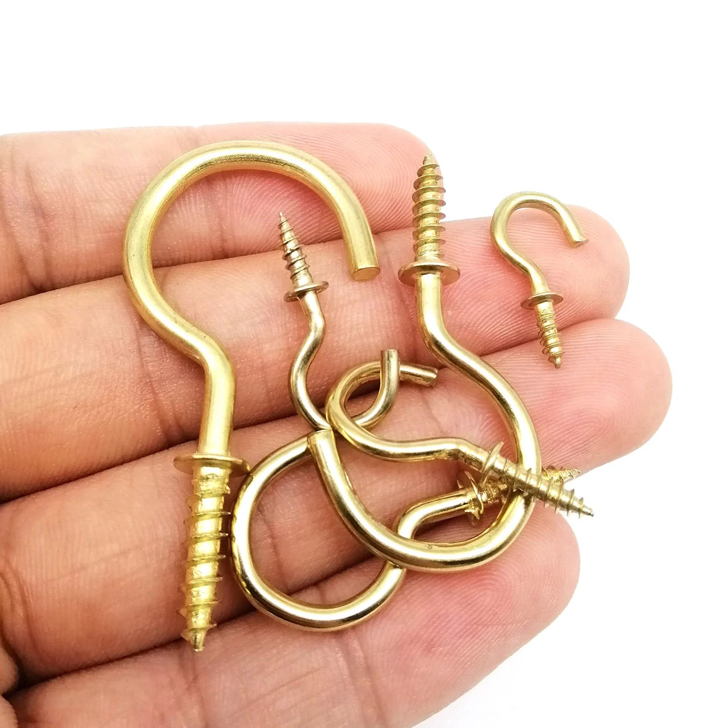 Installation de cadres photo avec cintres dorés sur un mur