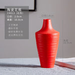 Vase décoratif en céramique rouge avec une texture rayée et des dimensions de 2,0 cm de diamètre et 16,0 cm de hauteur.
