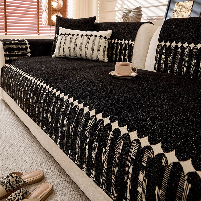 Un canapé décoré de motifs géométriques noir et blanc, avec des coussins assortis, offrant une ambiance élégante et sophistiquée dans cette pièce.