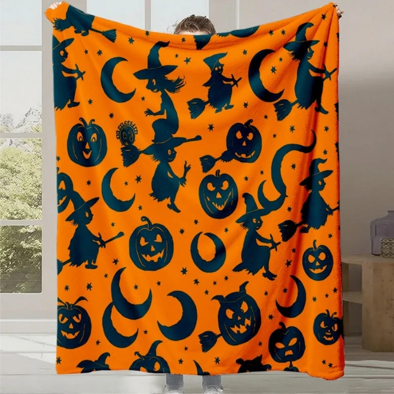 Couverture orange vif avec silhouettes noires de sorcières, de citrouilles d'Halloween et de lunes croisantes.