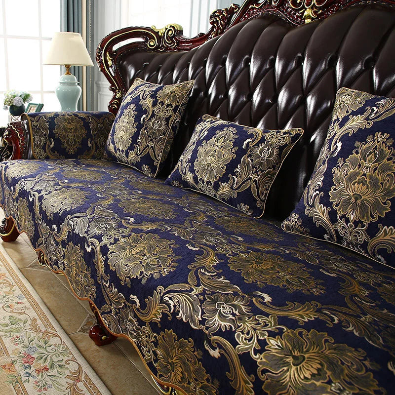 Un luxueux et élégant canapé capitonné de style baroque, avec des coussins ornés de motifs floraux dorés sur un fond bleu foncé, créant une ambiance sophistiquée et chaleureuse dans cette pièce.