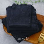 Gros plan sur un emballage noir avec le texte "Tian Mi Mi" écrit dessus, posé sur une surface en bois avec un couvert en or.