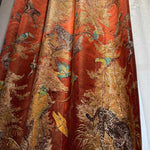 Tissu du rideau à thème jungle avec panthères, paresseux et perroquets sur un fond orangé, aux reflets luxueux et broderies texturées.