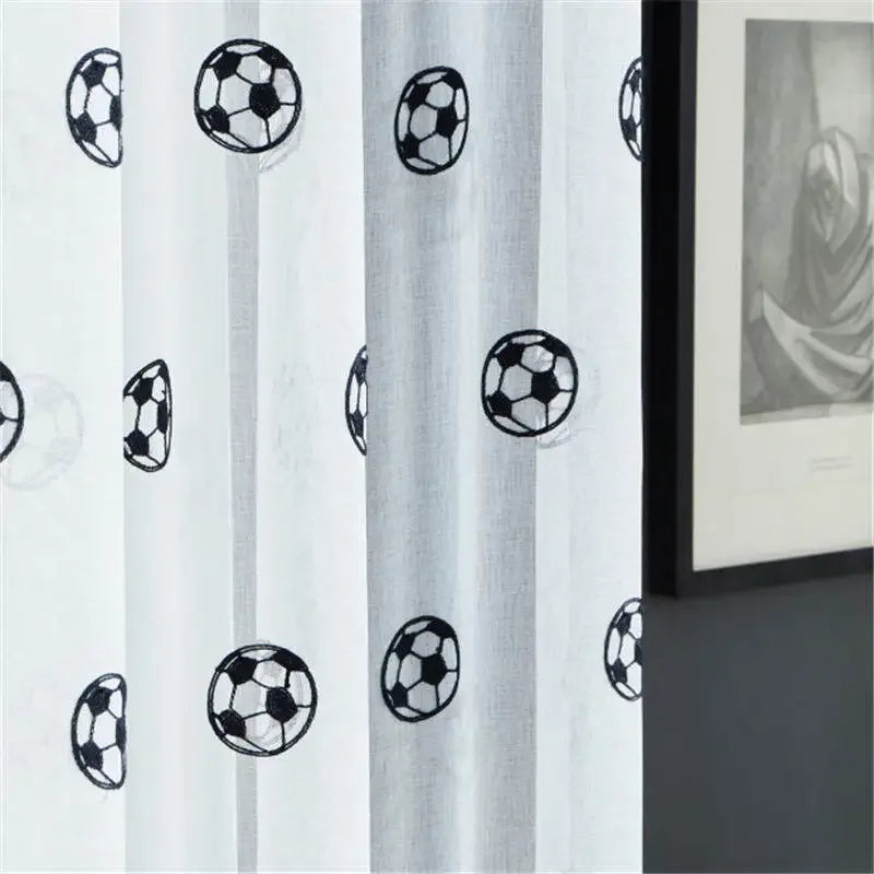 Zoom sur le tissu du rideau montrant des motifs de ballons de football avec effet de transparence.