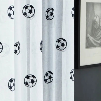 Zoom sur le tissu du rideau montrant des motifs de ballons de football avec effet de transparence.