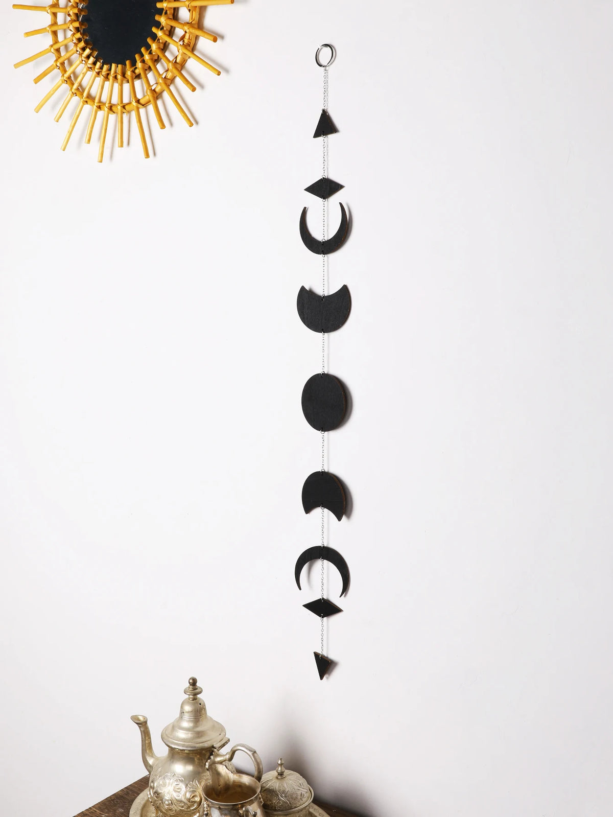 Détail de la guirlande murale phase de lune noire montrant les motifs en bois et la chaîne en métal