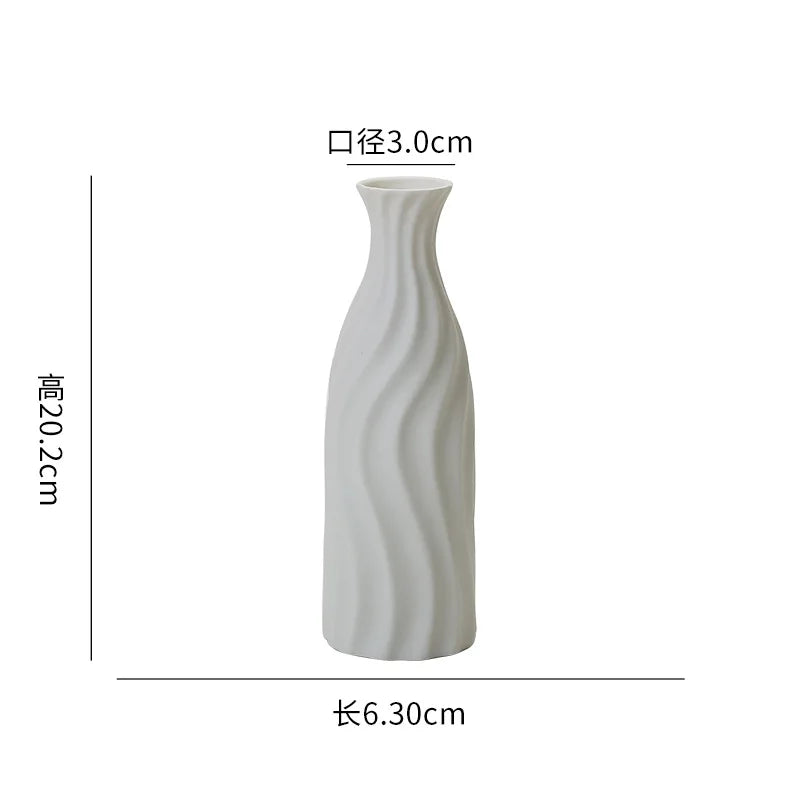 Un vase en céramique blanc aux lignes ondulées élégantes.