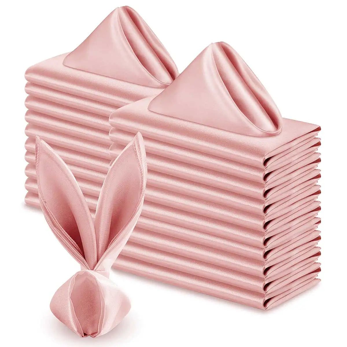 Une pile de serviettes de table roses en satin, pliées avec soin, forme un élément décoratif élégant et texturé.