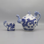 Un service à thé décoratif avec des motifs de dragons bleus et blancs, composé d'une théière et d'une tasse caractéristiques de l'artisanat traditionnel chinois.