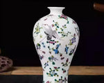 Vase en porcelaine blanc avec décoration florale multicolore et motif d'oiseau.