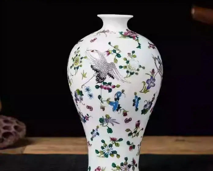 Vase en porcelaine blanc avec décoration florale multicolore et motif d'oiseau.