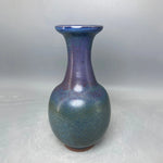 Un vase de poterie aux couleurs irisées et profondes, créant une impression de beauté et de sophistication.