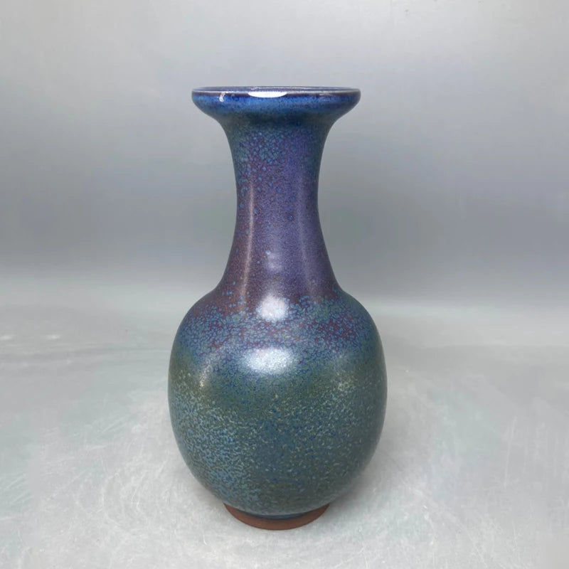 Un vase de poterie aux couleurs irisées et profondes, créant une impression de beauté et de sophistication.