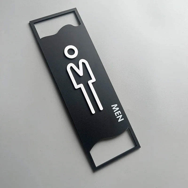 signalisation toilettes moderne symboles homme femme texte TOILET bois brun clair blanc tringle noire