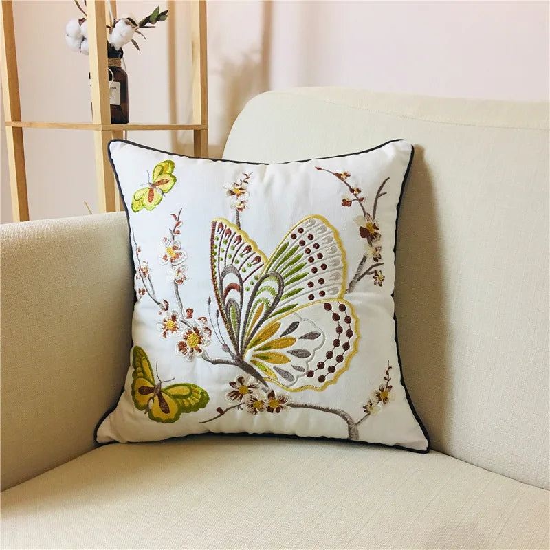 Coussin décoratif avec un magnifique motif de papillons brodés aux couleurs vives, créant une atmosphère chaleureuse et accueillante dans le salon.