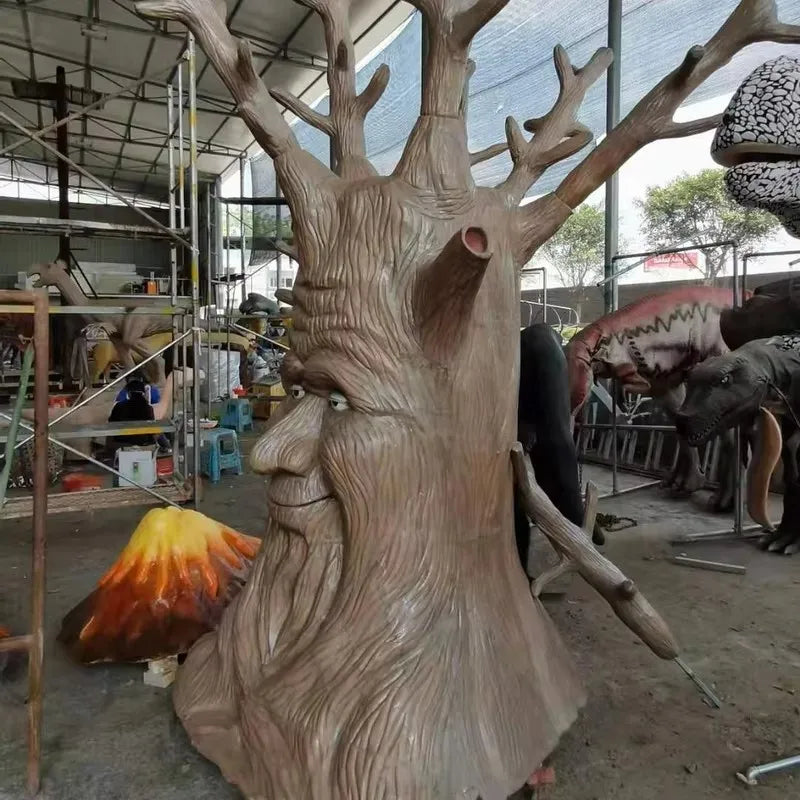 sculpture arbre anthropomorphique feuilles colorées marron vert orange texture bois yeux jaunes sourire